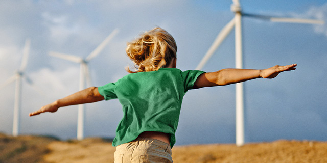 Syklo – kestävä kasvu. Lapsi juoksee kohti tuulivoimalaa kädet levitettynä.